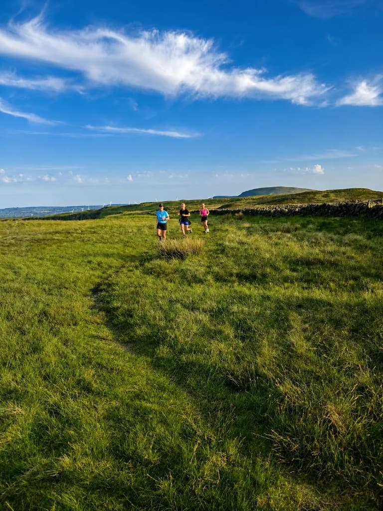 Glenlough runners on the hills beneath an open sky